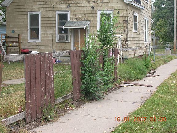 House before painted. Fence has been removed