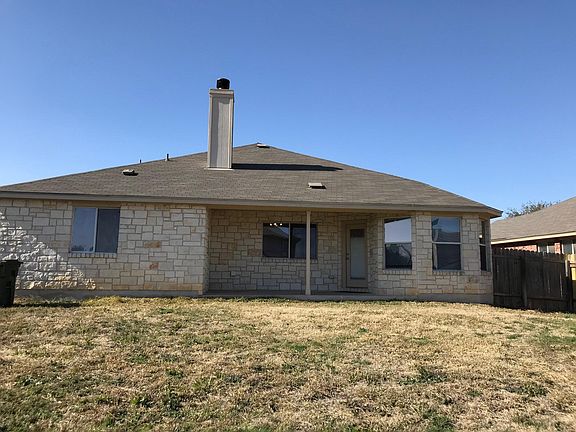 Back of home taken from fence line. Large sloping yard with ample room for a puppy.