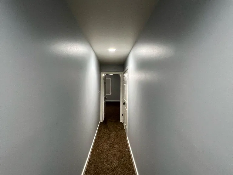 Looking down hallway at bedroom 3 (above garage) and doors at the end of the hallway on the right are for the washer/dryer