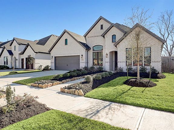 This fantastic home has incredible curb appeal with a traditional brick elevation, upgraded bronze windows, and upgraded exterior lighting.