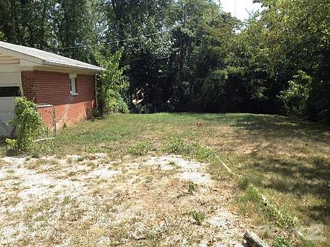 Yard behind garage fenced on 3 side