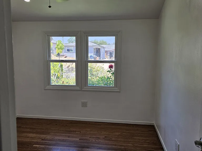 Right section of bedroom, highlighting windows and ceiling fan.
