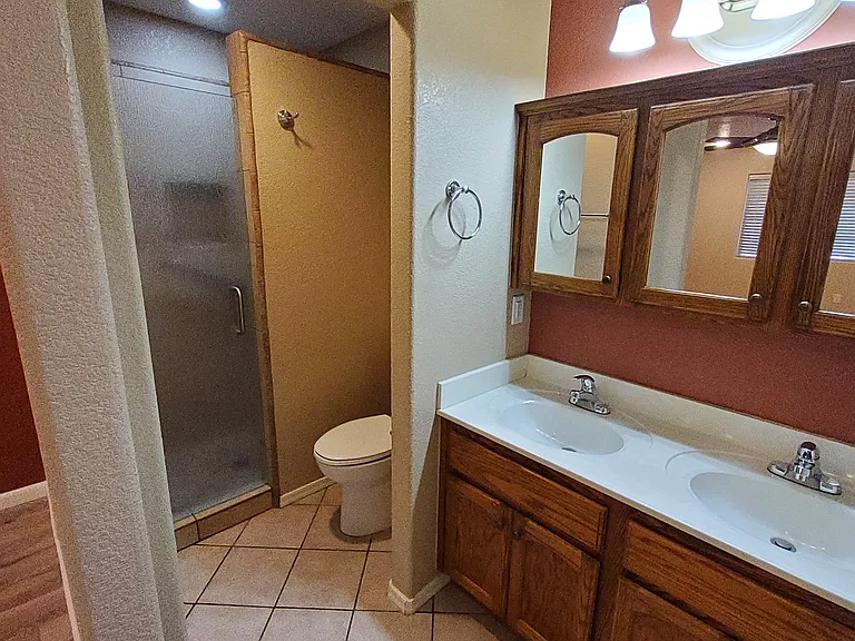 Master bathroom with double vanity, tiled shower