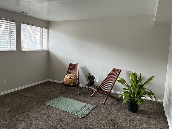 Large front room with lots of natural light from south facing windows, view of yard with beautiful scrub oak trees.