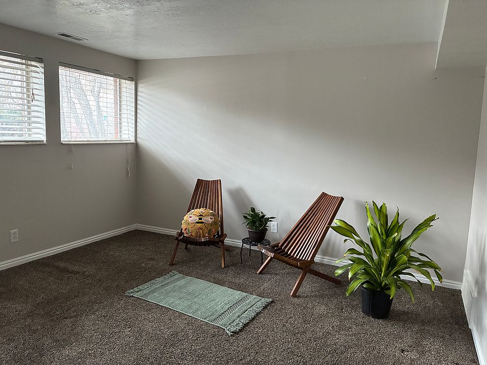 Large front room with lots of natural light from south facing windows, view of yard with beautiful scrub oak trees.