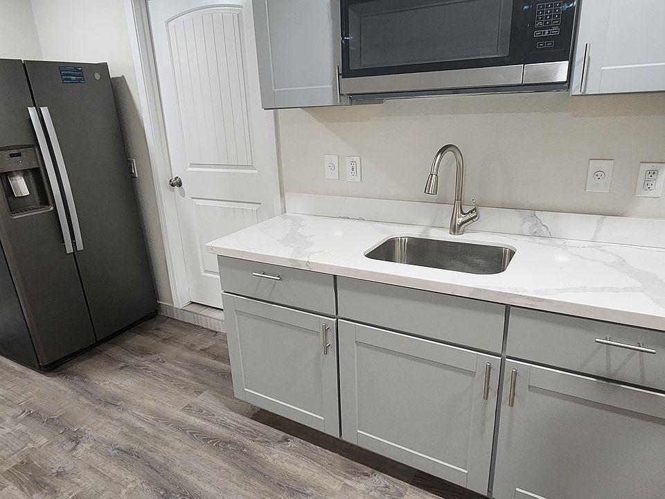 Alternate view of studio with kitchenette and fridge. Bathroom is to the right.