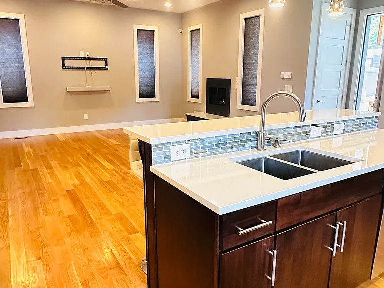 A view looking out toward the living room/den from the corner of the kitchen
