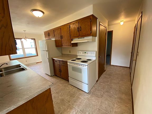immaculate kitchen with stove and refrigerator with new flooring, counters, sink and lights.