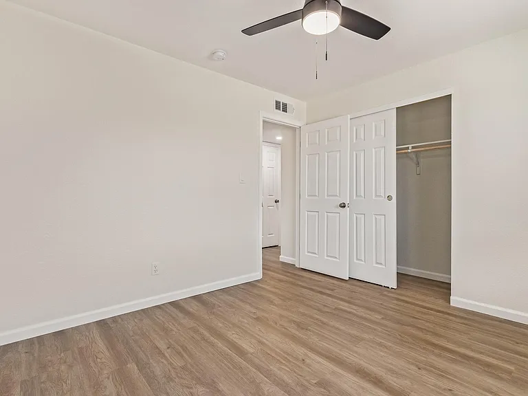 Another view of the bedroom showing the closet and the bedroom door entry.