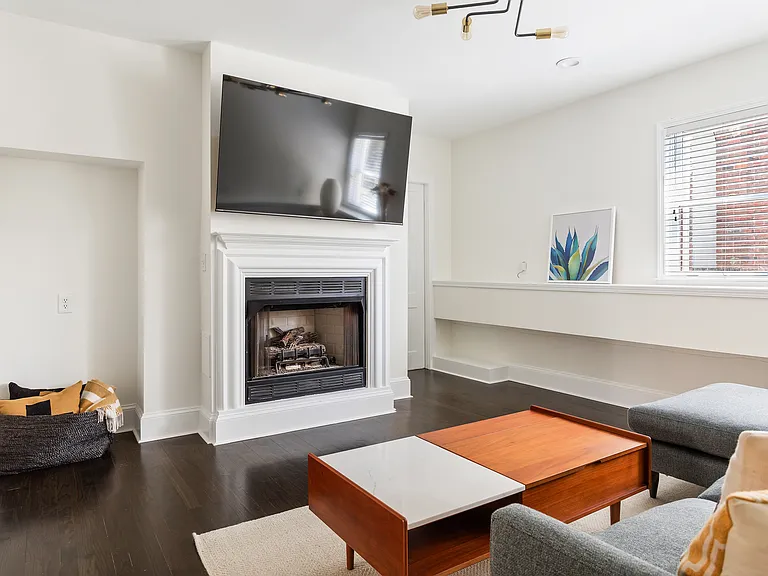 Main living room with fireplace and TV. New, comfortable sofa, and coffee table top lifts up for dining, scrolling, or working.