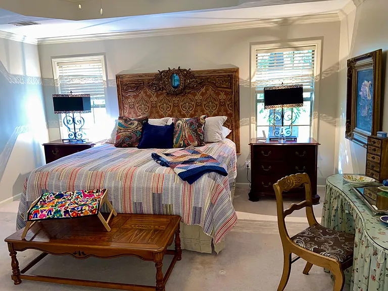 Huge primary bedroom with makeup or work station area, plus wall mounted TV using a connected streaming service.