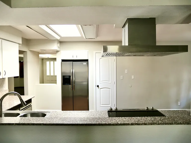 open concept, view from main living room into kitchen. pantry, fridge
