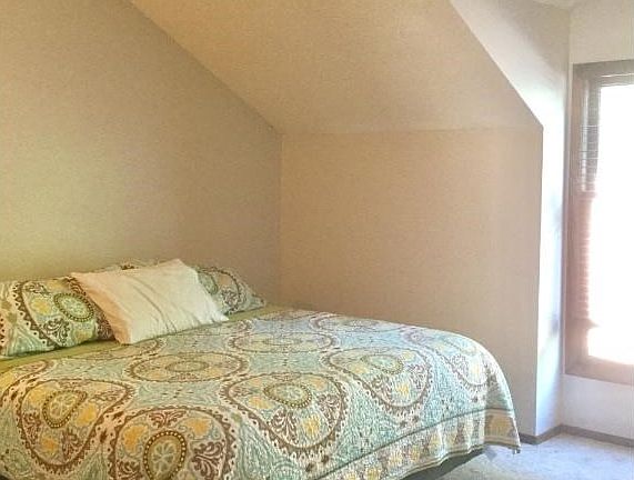 Upper bedroom with vaulted ceiling and large closet.