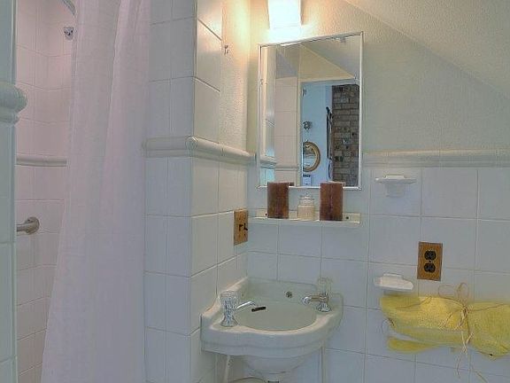 Lower level bathroom is tucked under the stairs. Tile shower is quite large.