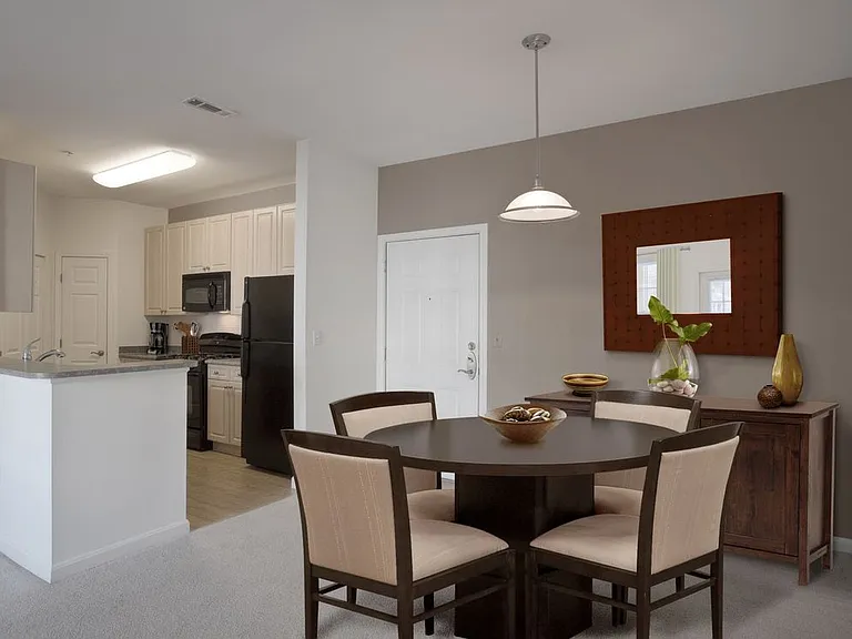 Phase I Classic Package II apartment kitchen and dining area with oak cabinetry and black appliances