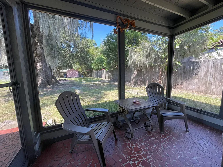 view of back yard through screened porch
