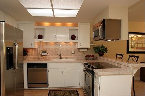 Kitchen with stainless steel package, under cabinet lights and laminate wood