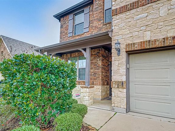 Brick and Stone Elevation. Notice Large covered front porch in wood, brick and stone. Coach Lighting and Keyless entry garage access. Wood Shutters .