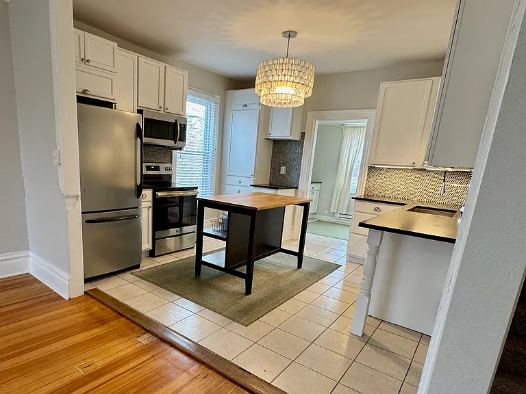 Kitchen open to living room and dining room, stainless appliances and gourmet faucet, island seating for 2