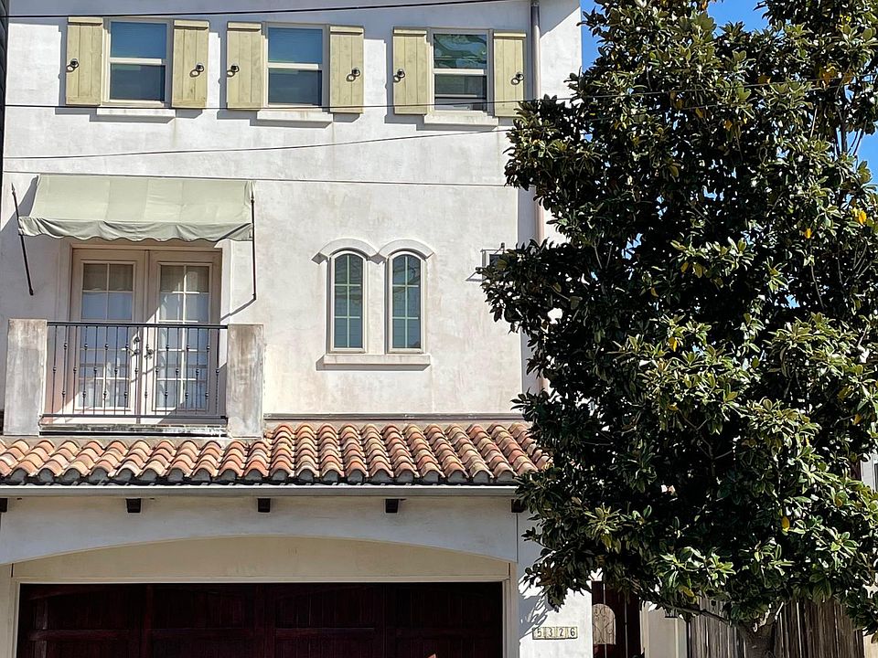 Two car garage and gated access to front door with mature miniature Magnolia.