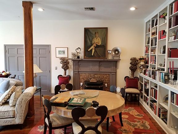 Another view of large living room and antique fireplace
