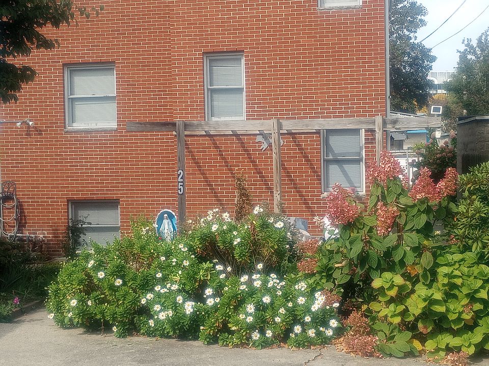Entrance. Parking spot in front of the white flowers