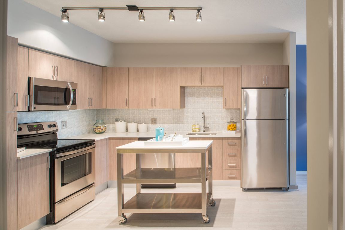 Gourmet designer kitchens with stainless steel appliances, track lighting, quartz countertops, and Italian kitchen cabinetry