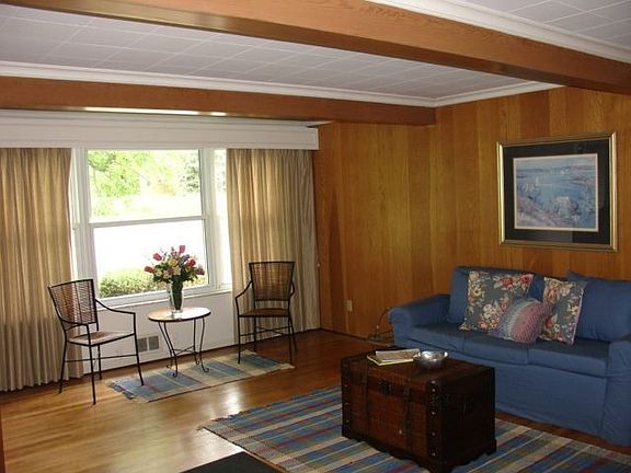 Living room has a beamed ceiling with gleaming hardwood floors!