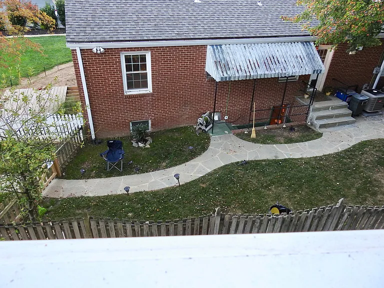 Aerial view of back of house. Shows stairs to basement entrance.