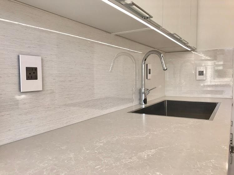 Under cabinet lighting with modern back splash and quartz co