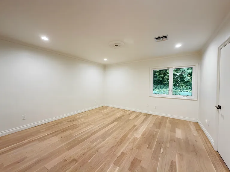 Serene tree-view window brightens this unfurnished bedroom in a quiet corner of a Beverly Hills luxury rental at 1094 Garden Lane, 90210.