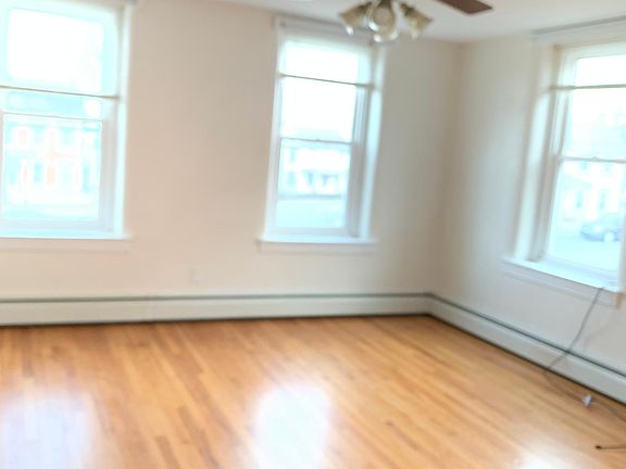 Livingroom w/ lots of natural light and ceiling fan.