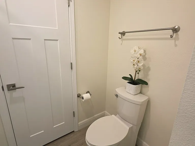 Hallway bath toilet with smooth sides for easy cleaning