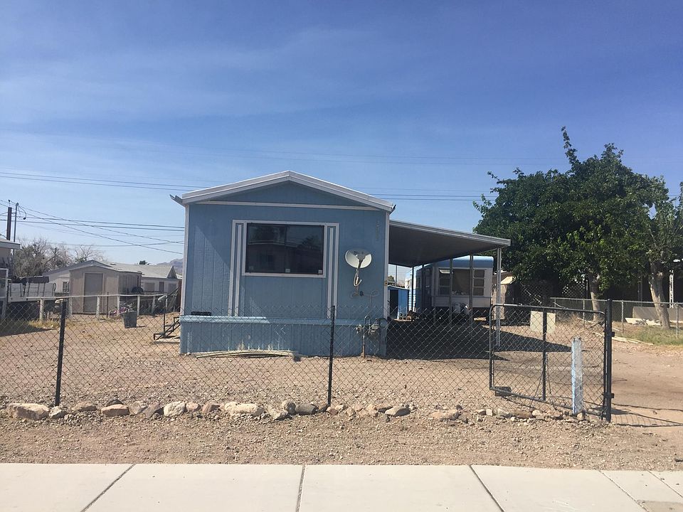 Exterior of Mobile Home and Small Storage Trailer