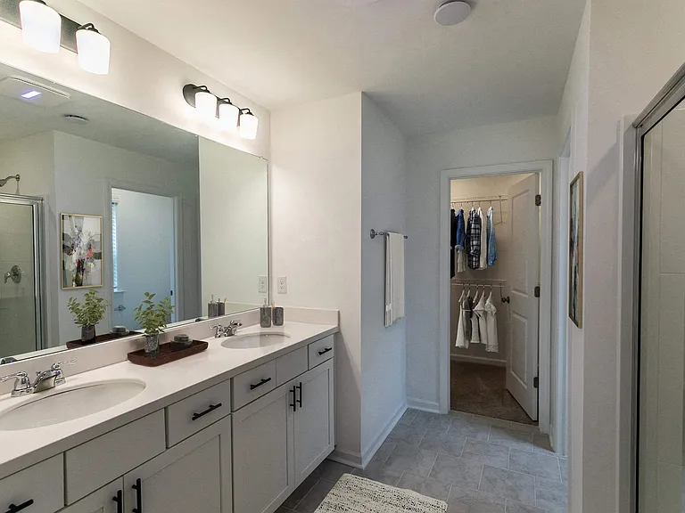 Primary bathroom with double vanity, walk-in shower and walk-in closet.