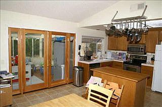 Butcher block Island with SS Potrack overhead.  French doors lead to Sunroom.