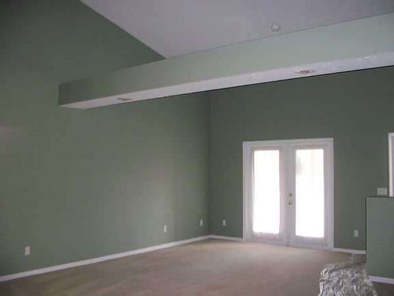 Vaulted living room with French Doors leading to screened pa