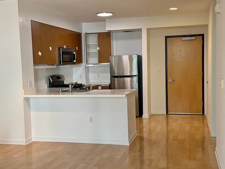 Kitchen with breakfast bar. Stainless steel appliances - refrigerator, dishwasher, stove/oven & microwave.
