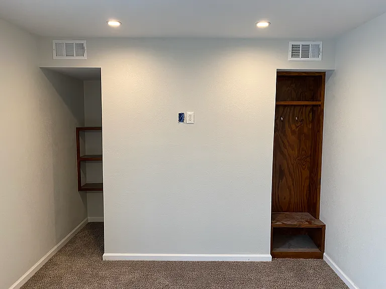 Walk in shelving closet. on the left, foot locker on the right.