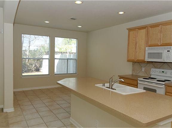  Open Kitchen with Corian Counters, Tile Back Splash, Tile Floors, Walk In Pantry and Breakfast Bar.