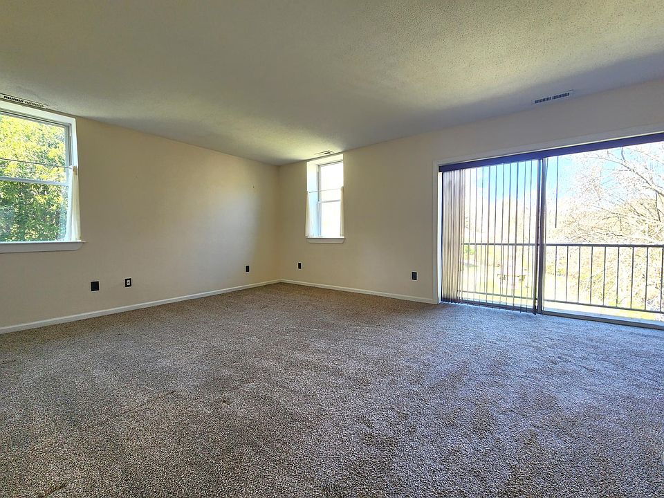 Large Living Room with Private Balcony overlooking brook and landscaped grounds