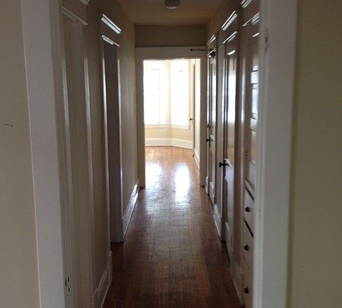 Hallway looking from dining room toward living room. Bedroom on the left down hallway