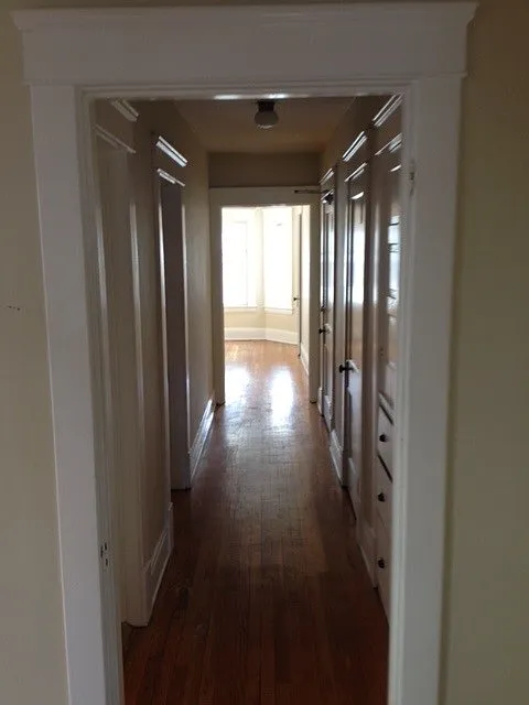 Hallway looking from dining room toward living room. Bedroom on the left down hallway