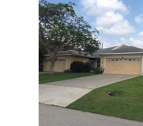 Front of Duplex with 2 car garages on each side and side walks leading to each entry door