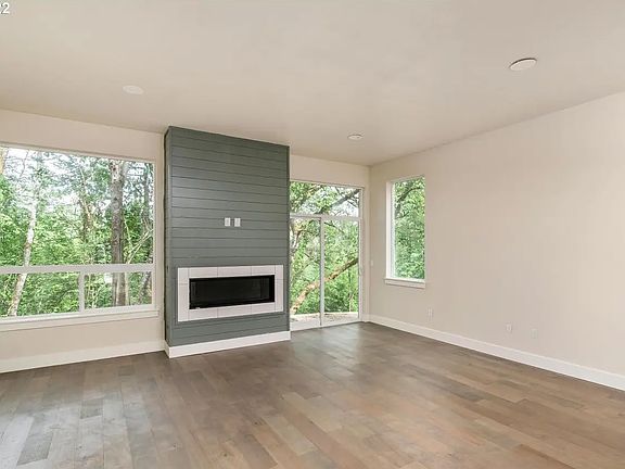 Open space living room with kitchen and a great view of the greenspace behind it. Very Light and Bright!