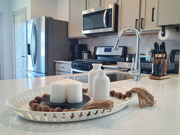 Kitchen with ample counter space, stainless steel appliances, and a large island with sink for easy meal prep.