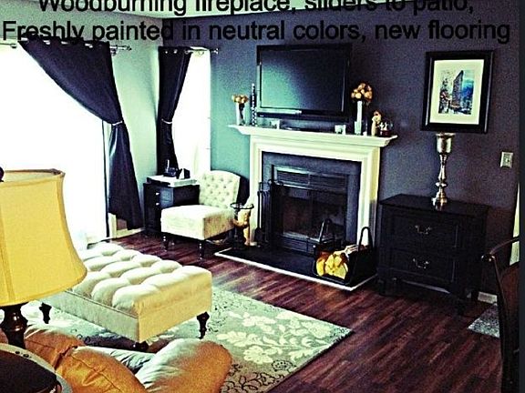 Large living room with sliders to private patio. Wood burni