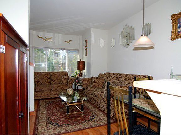 Dining and Living area with pendant lighting over tile bar.