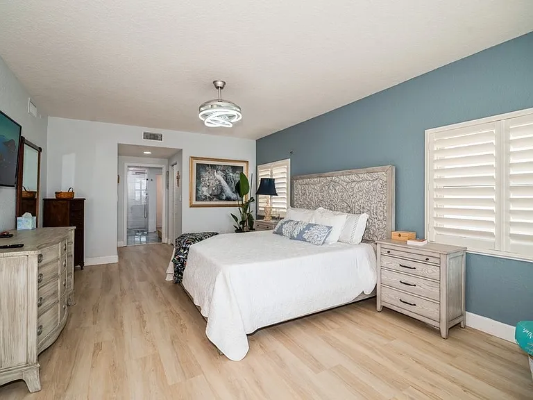 Primary bedroom with king size adjustable bed, smart TV and 2 walk -in closets