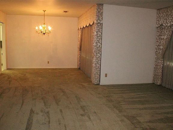 Here is another view of the formal areas.  The carpet is in good condition or you could refinish the original hardwoods floors.